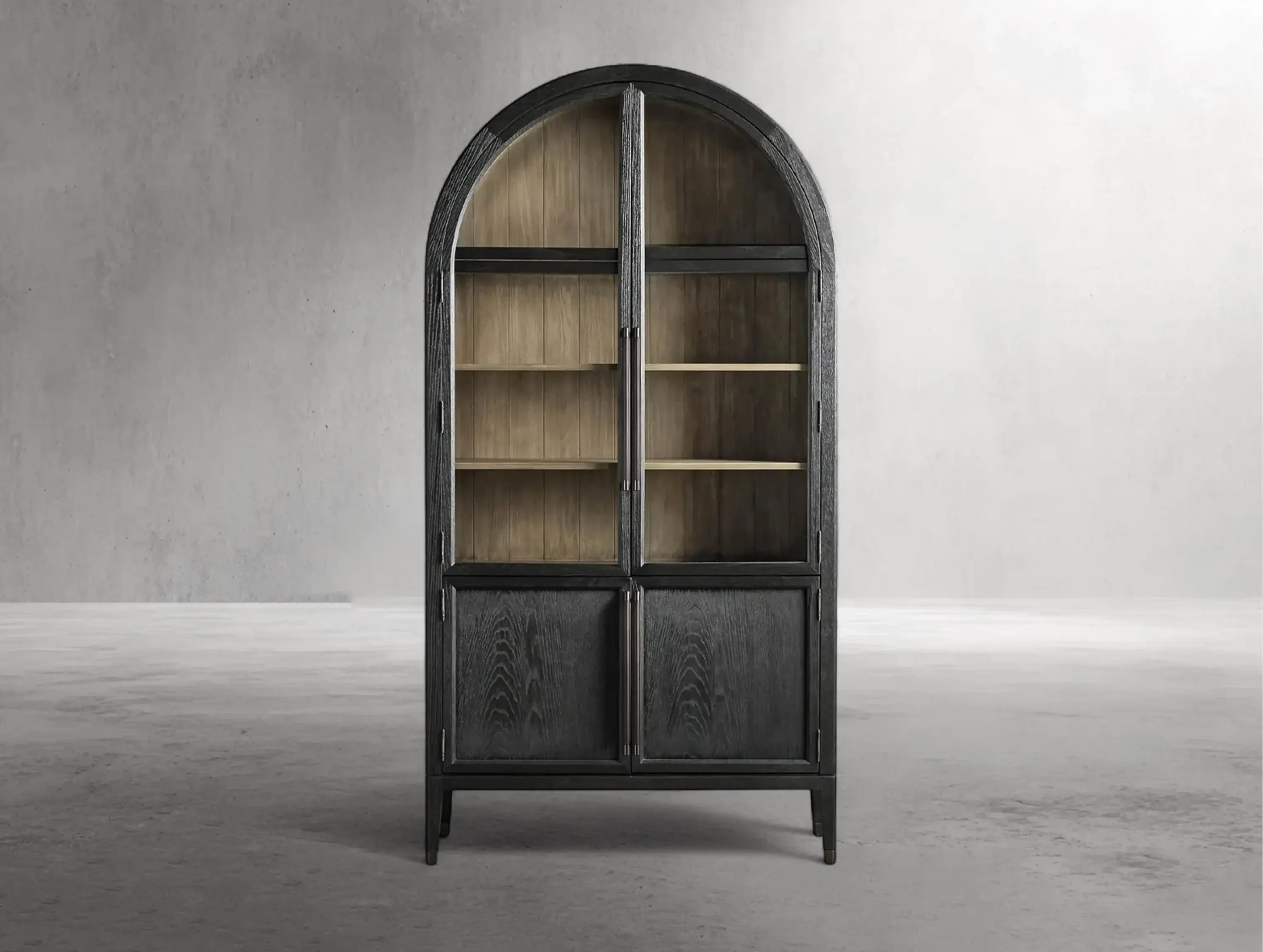 Arched bookshelf with wooden shelves and dark metal frame against a gray concrete wall.